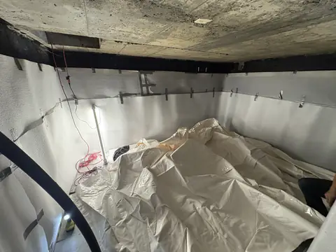 Custom cistern liner unrolled on the padded floor before fitting