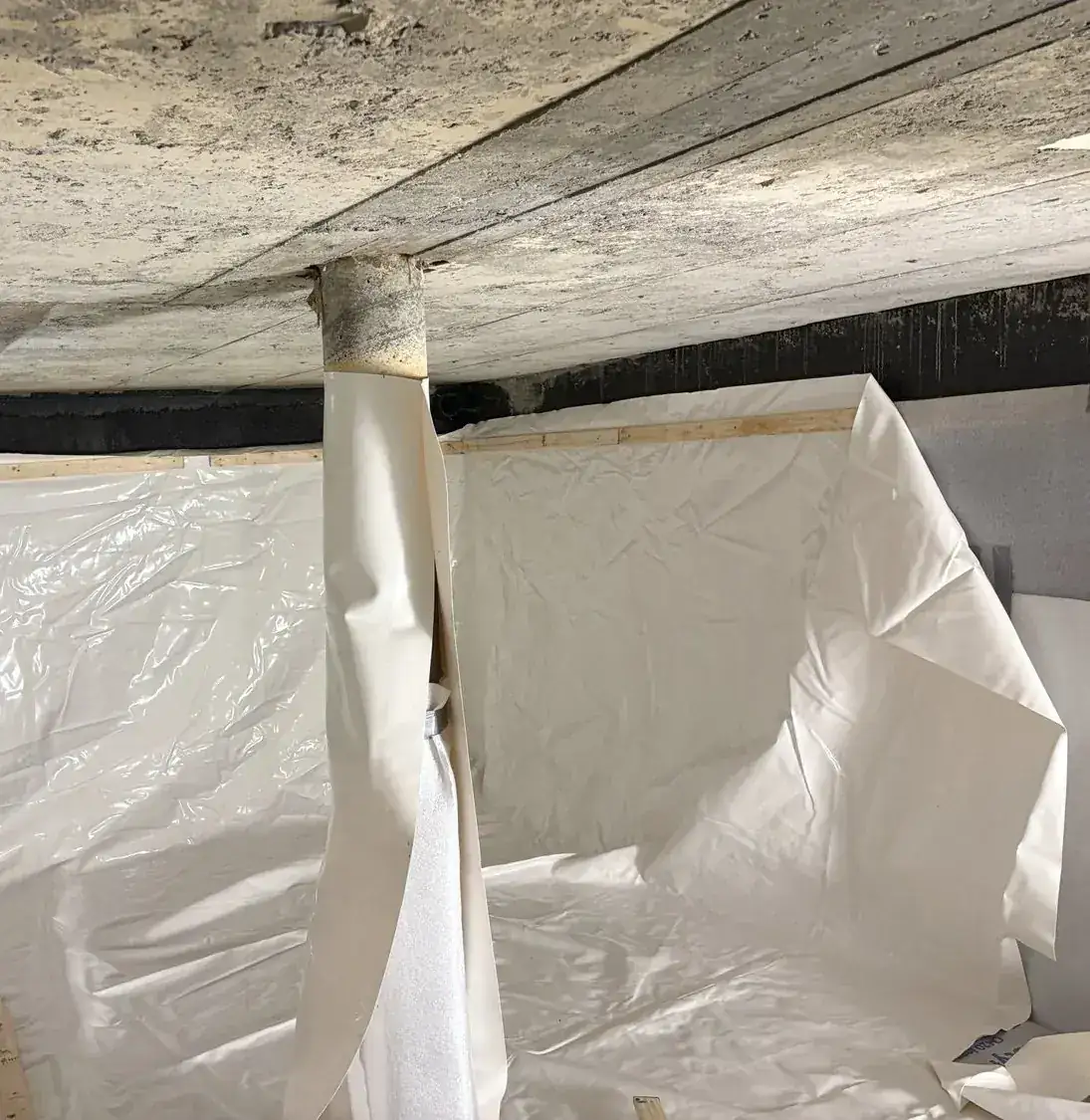 Cistern liner installation: Fabricated liner sleeve being fitted around a foam-wrapped column.