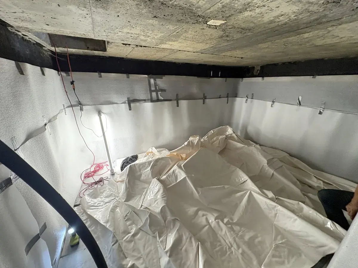 Cistern liner installation: Liner unfolded onto the foam-covered floor, with the walls ready behind it.